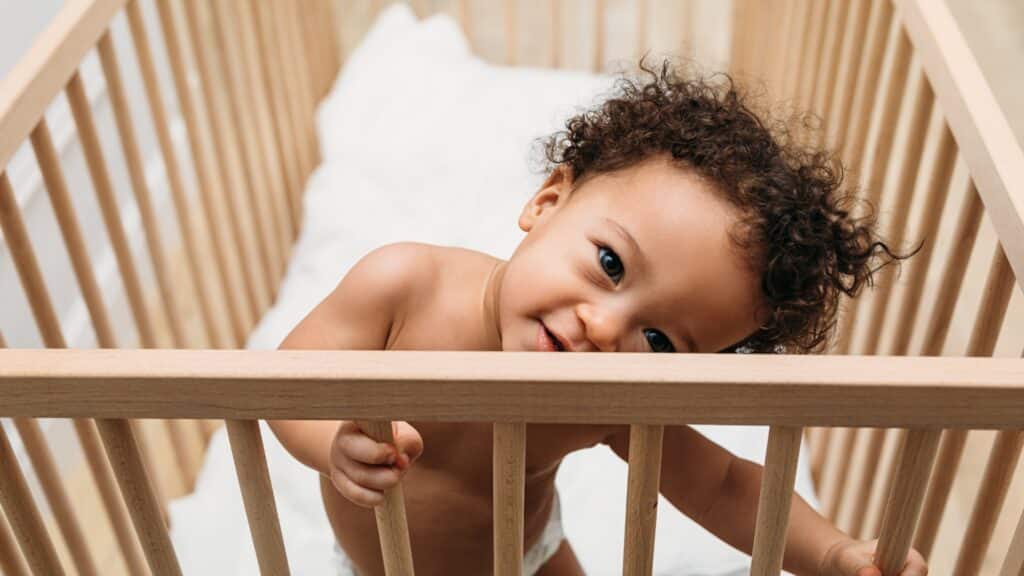 When Do Babies Drop A Nap - Baby Boy standing In His Crib